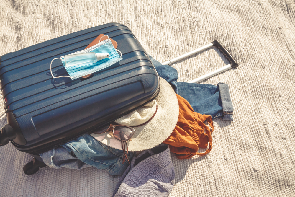 suitcase with clothing on a beach