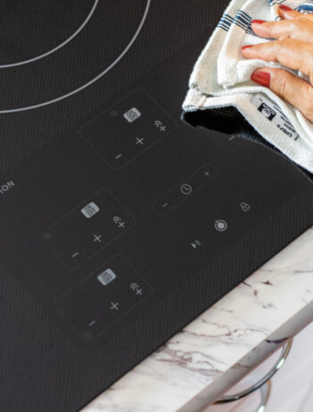 person wiping an induction cooktop