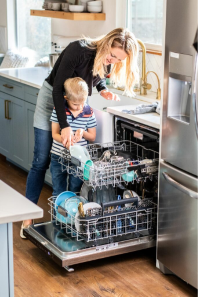 mother and child putting in dishes in the dishwasher