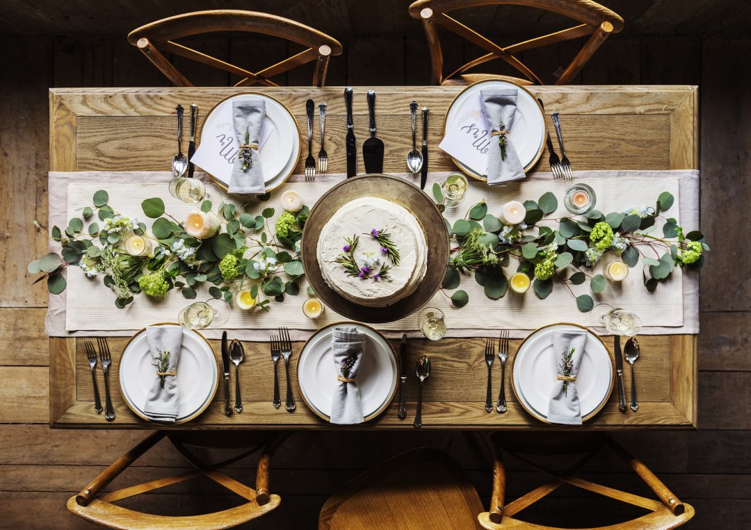 Table setting for five people with flowers.