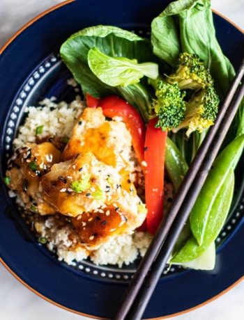 Sweet and sour chicken with broccoli and chopsticks.