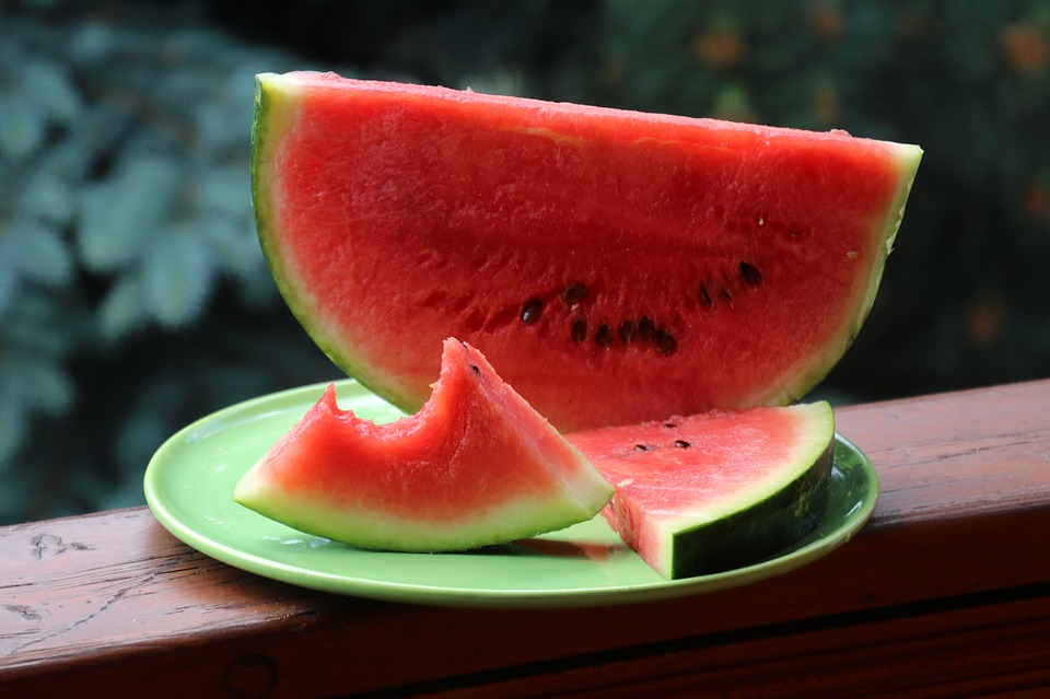Sliced watermelon on a wooden ledge.