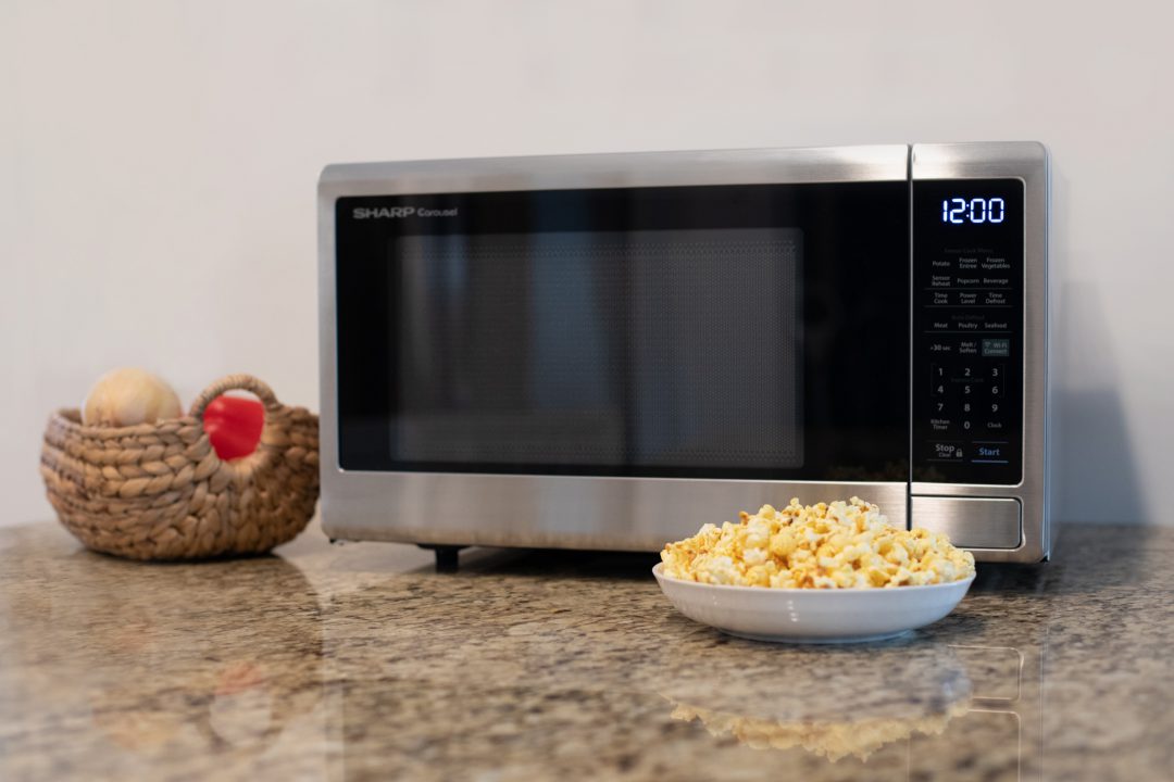 bowl of popcorn in front of a microwave