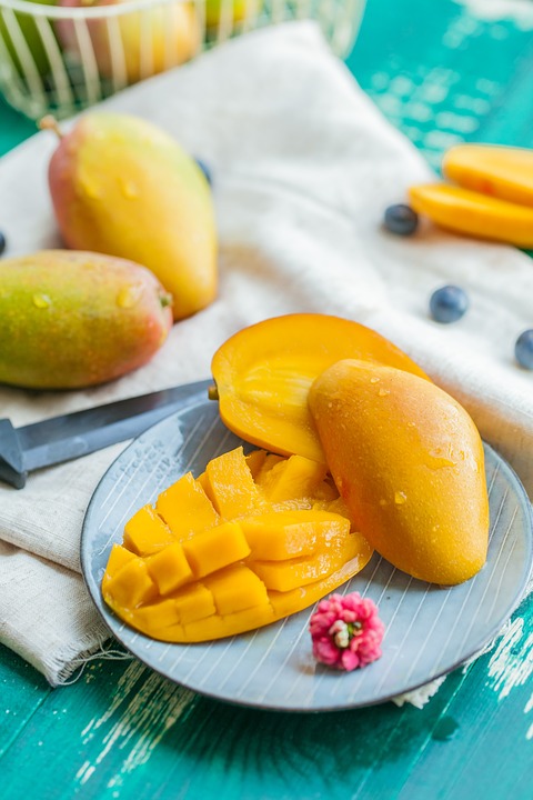 Mango dessert on a plate next to mangos.