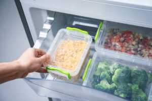 containers of food being put in a fridge drawer