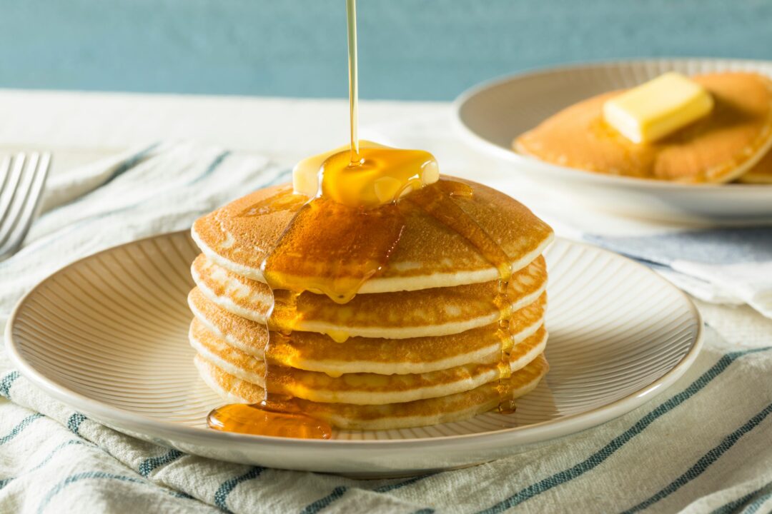 stack of pancakes with butter and syrup drizzle
