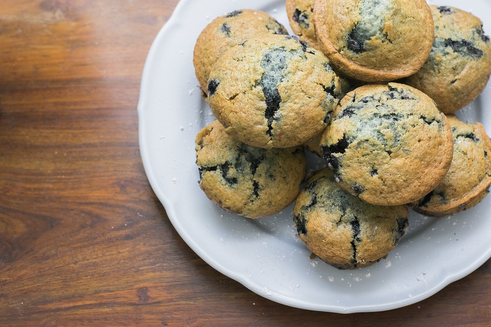 Blueberry muffins on a plate on a wooden table.