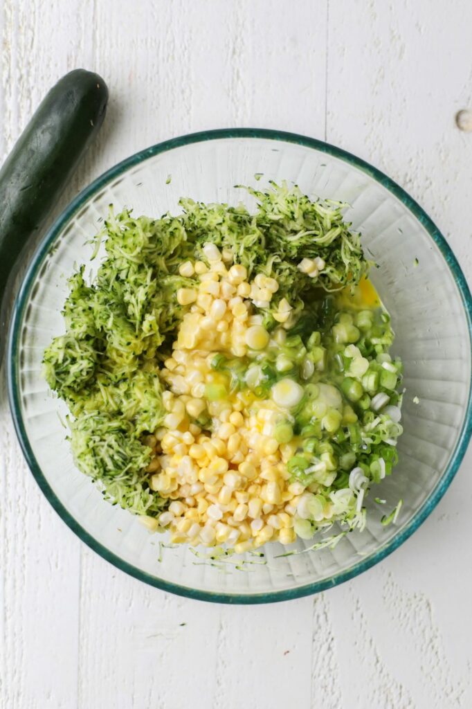 Ingredients for zucchini and corn fritters in a bowl