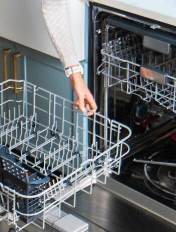 woman removing bottom rack of sharp dishwasher