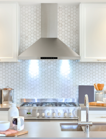 SHARP Range Hood with lights on in a white kitchen