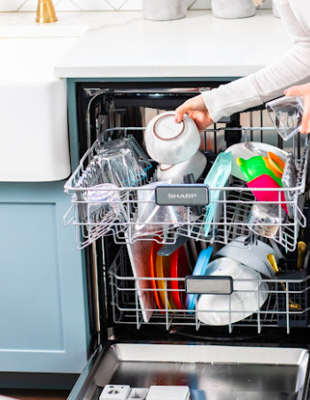 SHARP Dishwasher being loaded with dishes by a woman