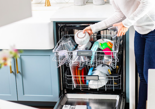SHARP Dishwasher being loaded with dishes by a woman