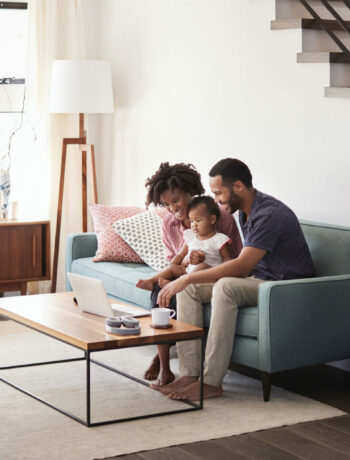 Family in their home, sitting at a coffee table with their air purifier