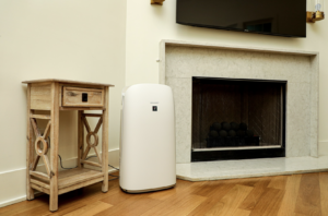 Sharp air purifier next to accent table and fireplace 