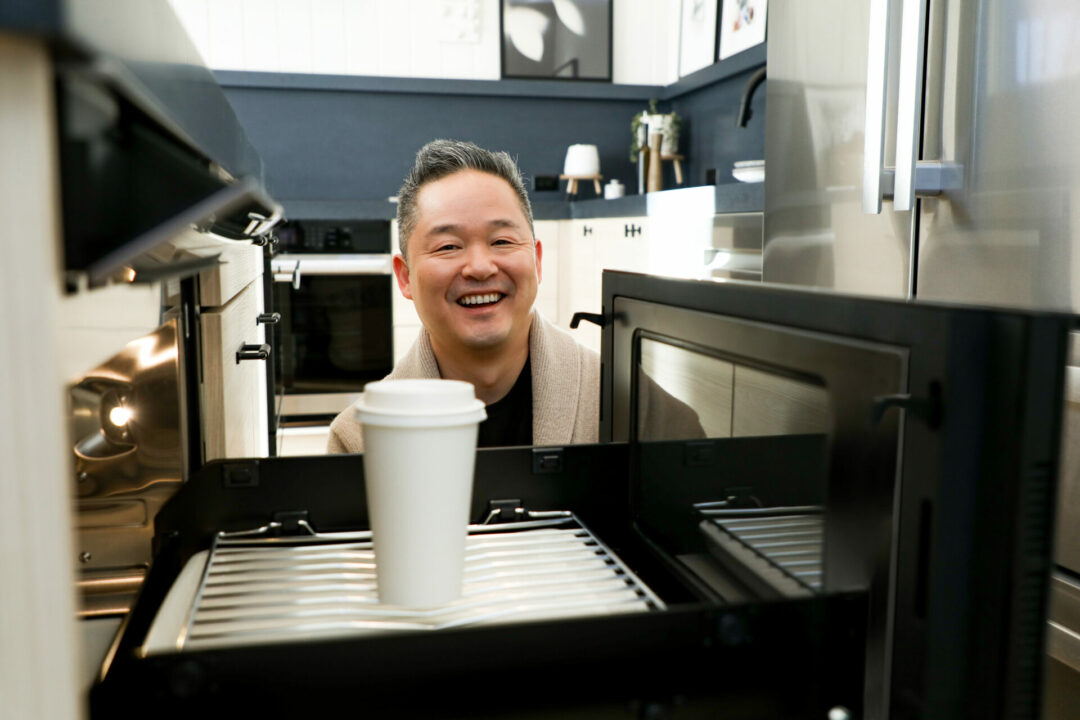 Man heating up coffee in Sharp Microwave Drawer Oven