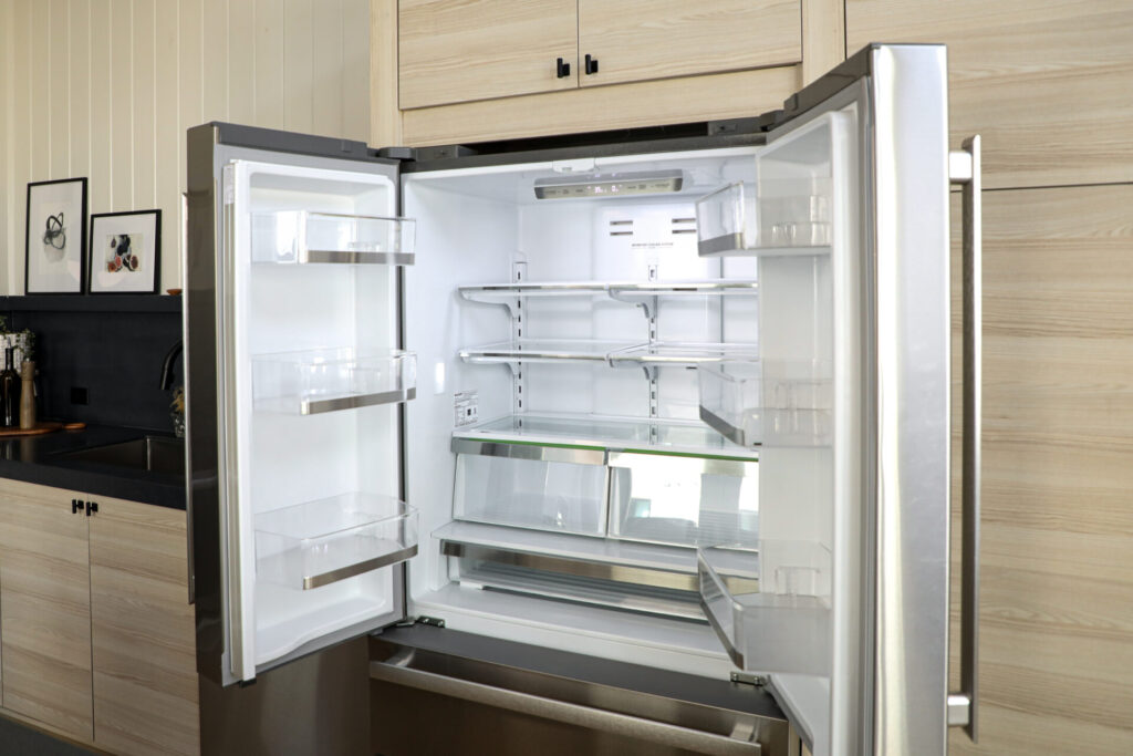 Sharp Refrigerator in a modern home with the doors open and empty shelves