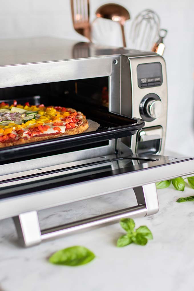 Pizza coming out of a Sharp Supersteam Countertop Oven.