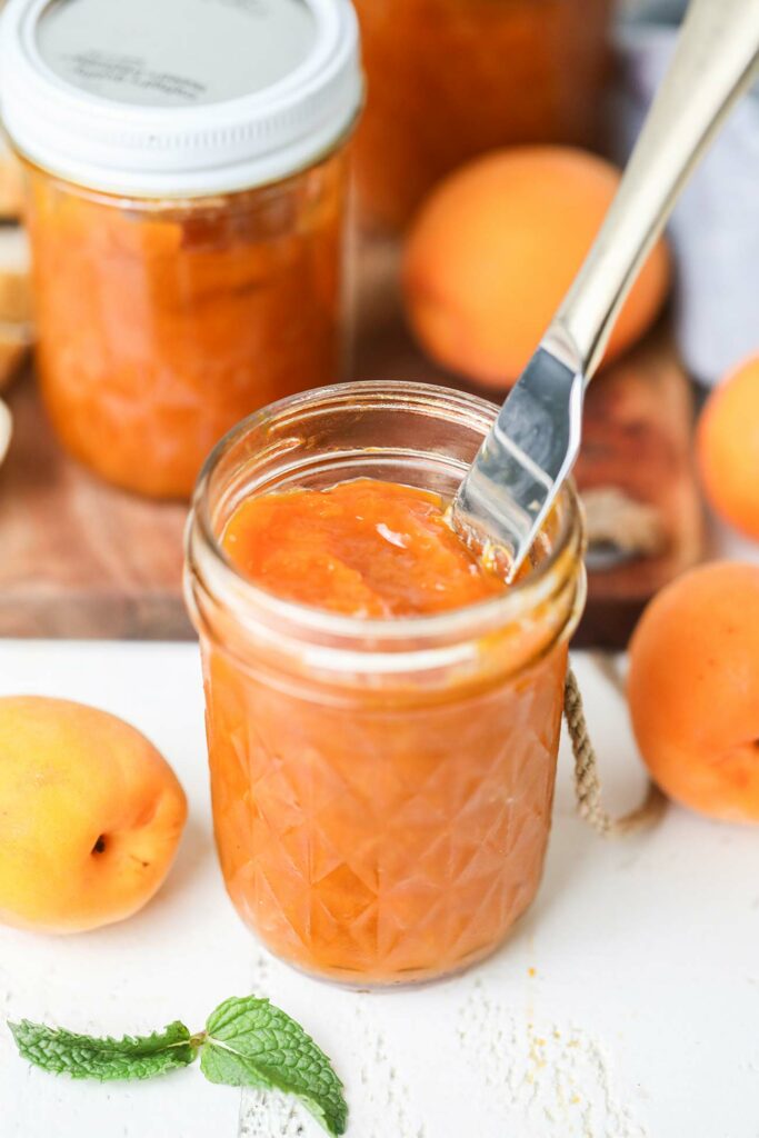 Apricot jam in a jar with a fork in it
