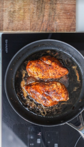 balsamic chicken cooking in a pan on a sharp cooktop
