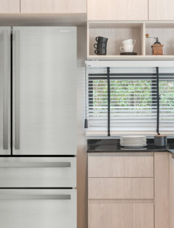 The Sharp French 4-Door Counter-Depth Refrigerator with Water Dispenser (SJG2254FS) in a kitchen.