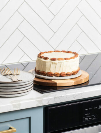image of a hummingbird cake on a stovetop with plates and silverware on the side