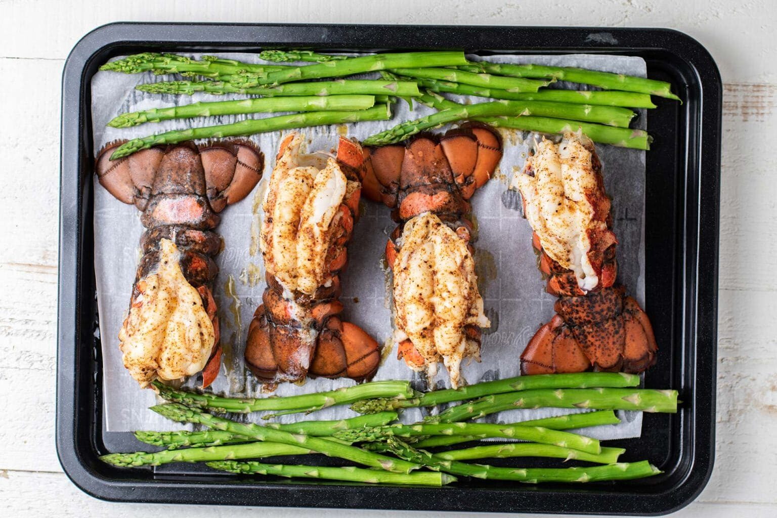 broiled lobster and asparagus on a tray