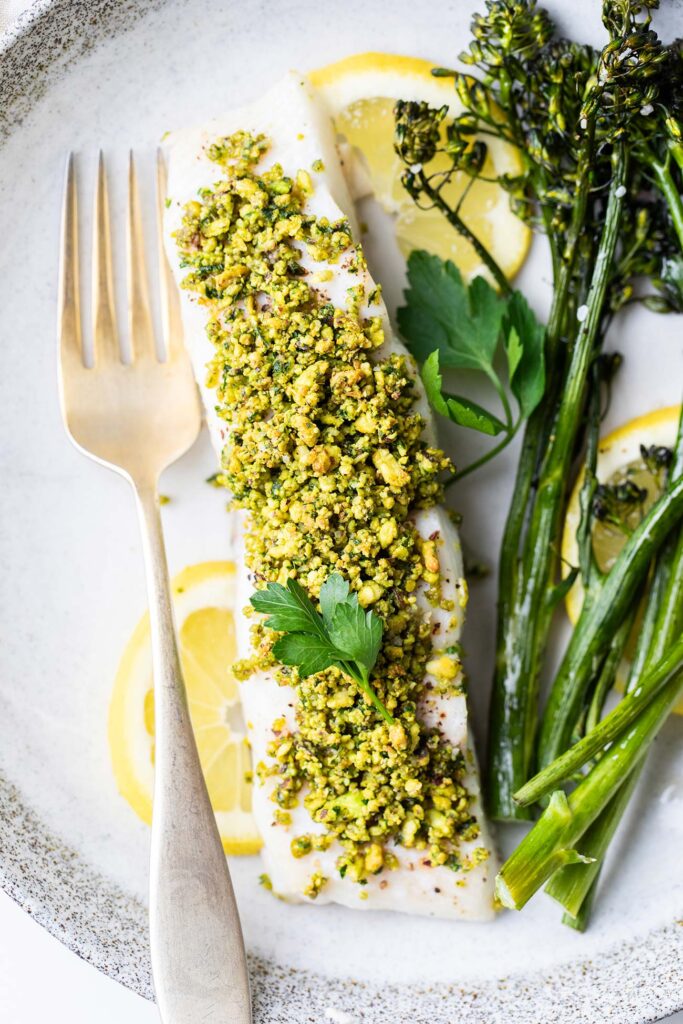 Pistachio crusted halibut plated with a side dish