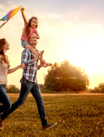 image of a family running through a field and laughing