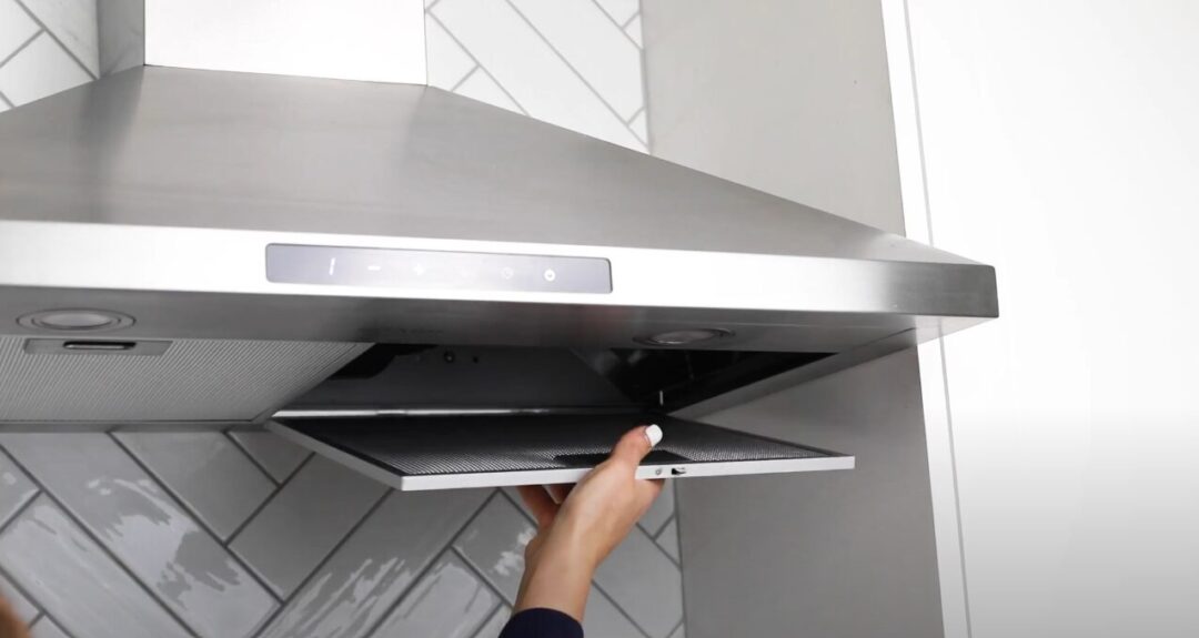 Woman removing grease filter from Sharp Range Hood