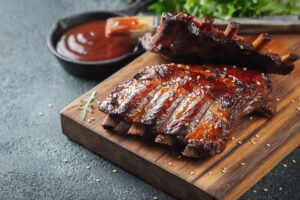 Cooked Pork Ribs on a cutting board with sauce 