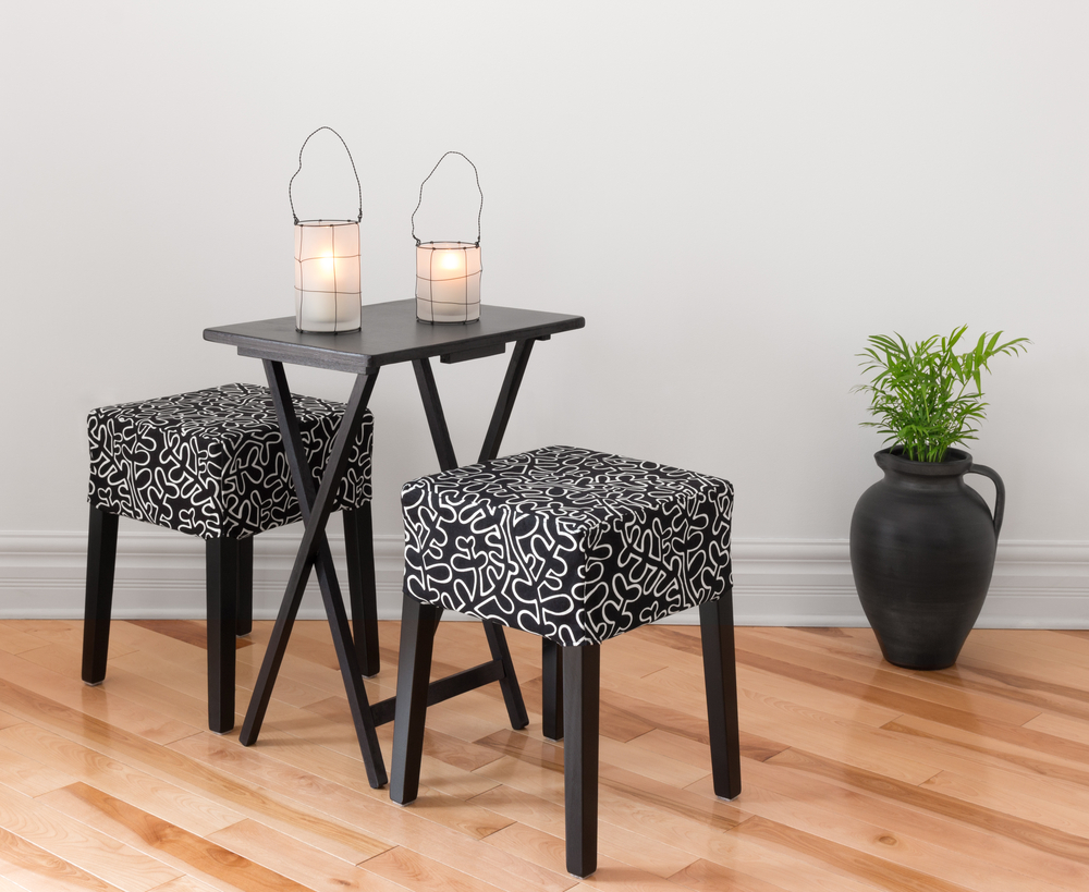 A folding table with two stools and two lanterns