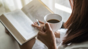 Woman holding a mug and reading a book