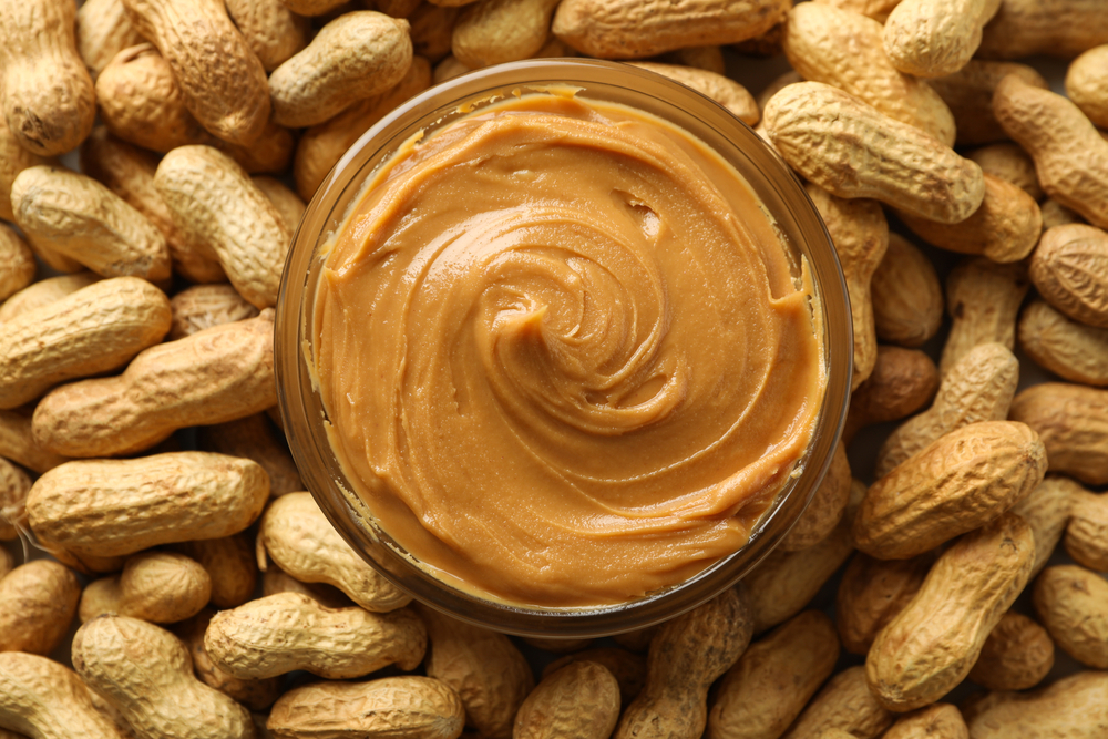 Peanuts and peanut butter in a jar for national peanut butter day on January 24th