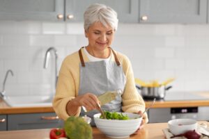 older woman preparing a salad