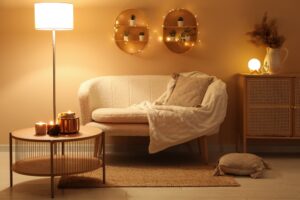 Modern interior of living room with stylish sofa and burning candles on table