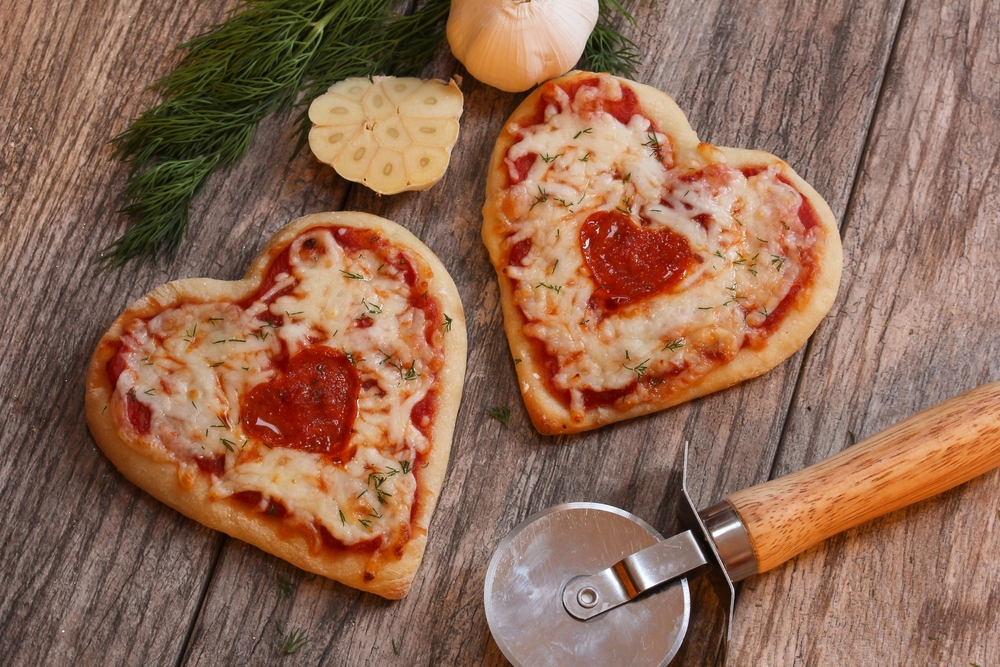 Heart shaped pizza on a cutting board 