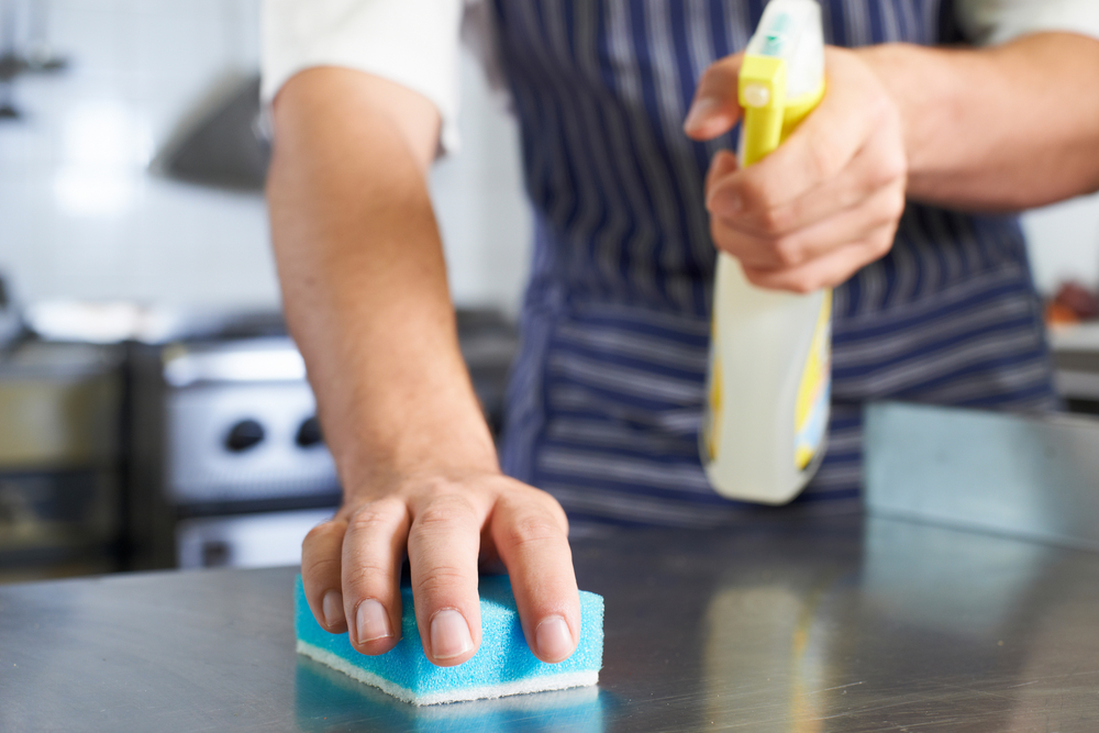 Surface being wiped down and cleaned with a sponge and spray bottle