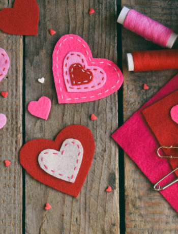 Valentine's Day red and pink hearts and craft supplies on a wooden background